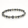 Pulsera de rosario con cuentas gris oscuro y medallones plateados con símbolos religiosos.