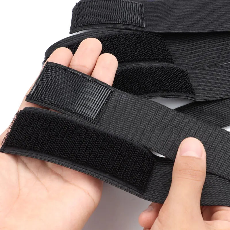 A hand is holding black elastic wig bands for hair edges.