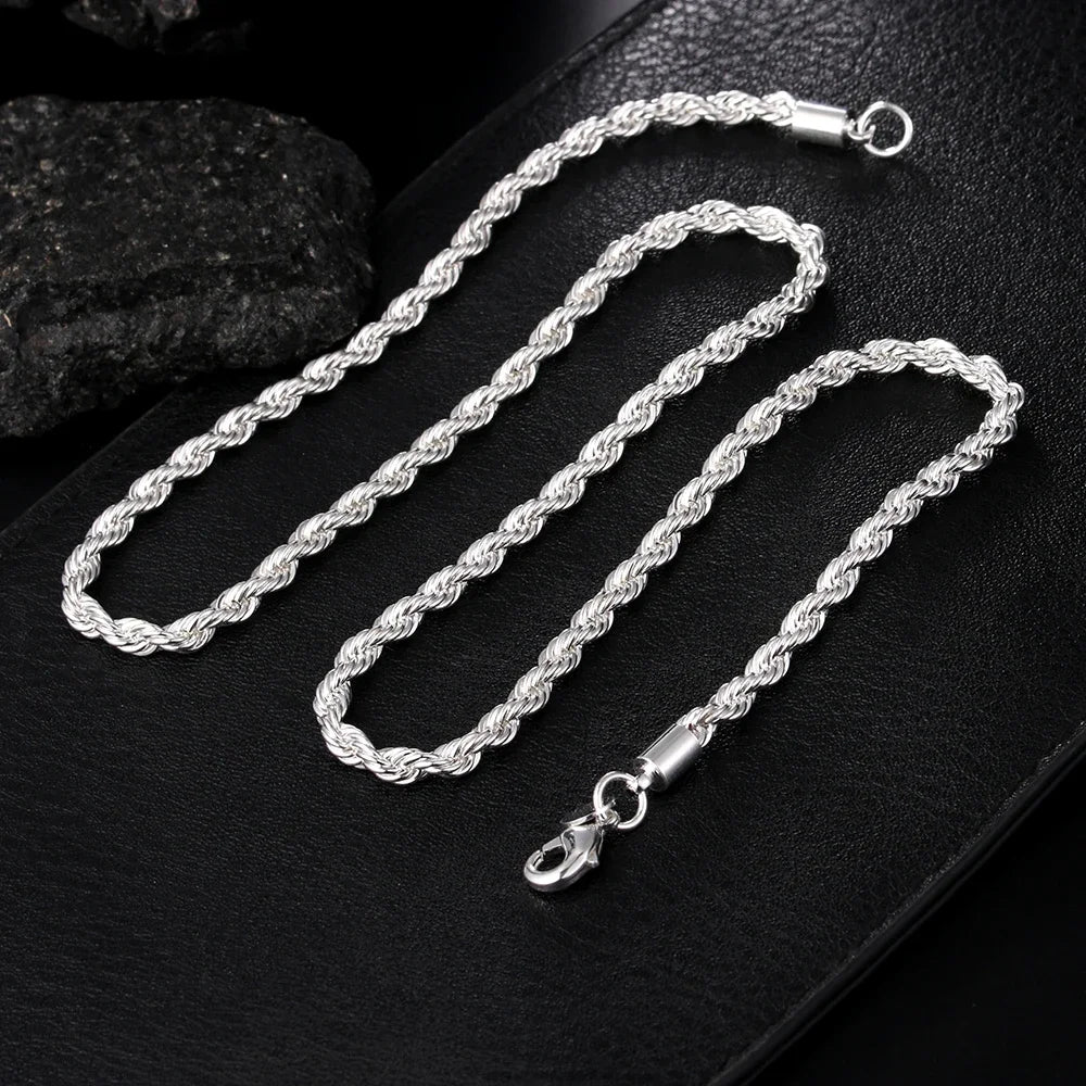 A set of twisted rope necklaces and bracelets made of 925 sterling silver displayed on a black surface.
