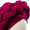 A deep magenta braided turban cap for African party headwear displayed on a mannequin.