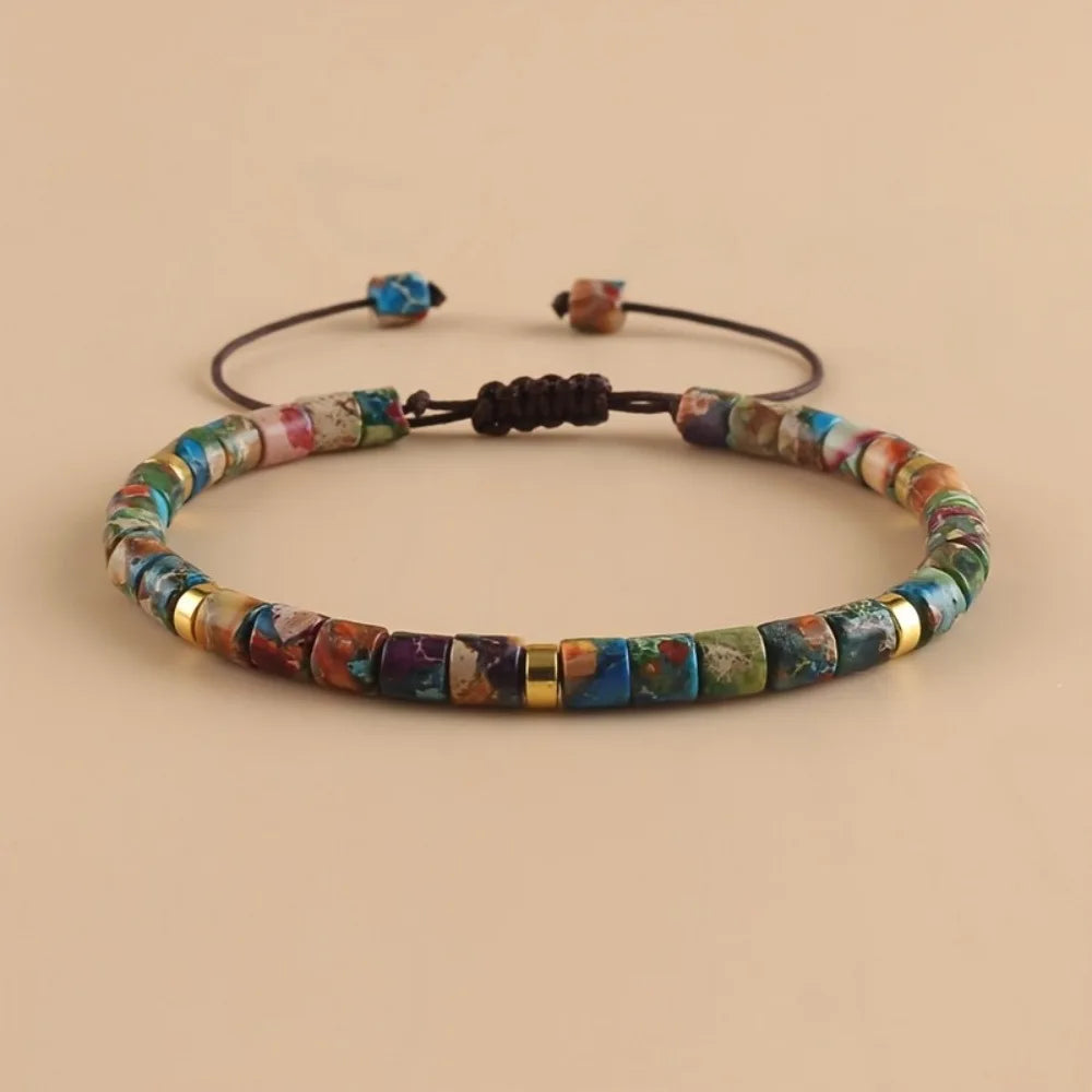 A friendship bracelet made of colorful natural stones, featuring various shades of blue, green, and purple.
