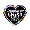 A black heart enamel pin with the text Following My Weird Little Heart surrounded by colorful scalloped edges.