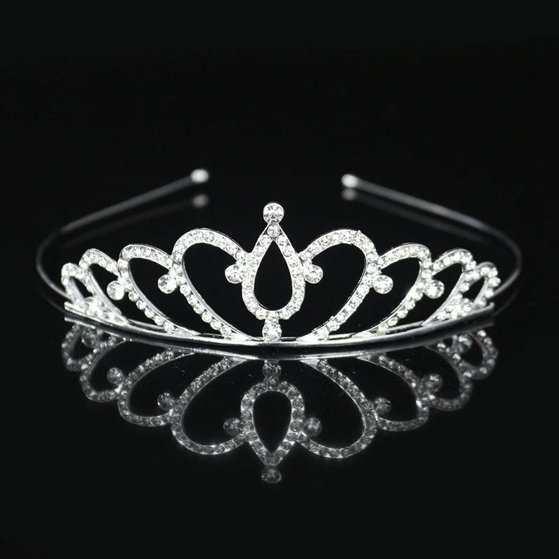 Tiara y corona de princesa de cristal brillante, accesorio para el cabello, exhibido en una superficie reflectante.