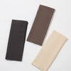 Three solid color fashion headbands in black, brown, and beige laid diagonally on a white background.