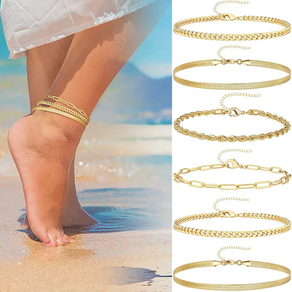 A set of three gold-toned stainless steel anklets displayed next to a woman's foot in the water.