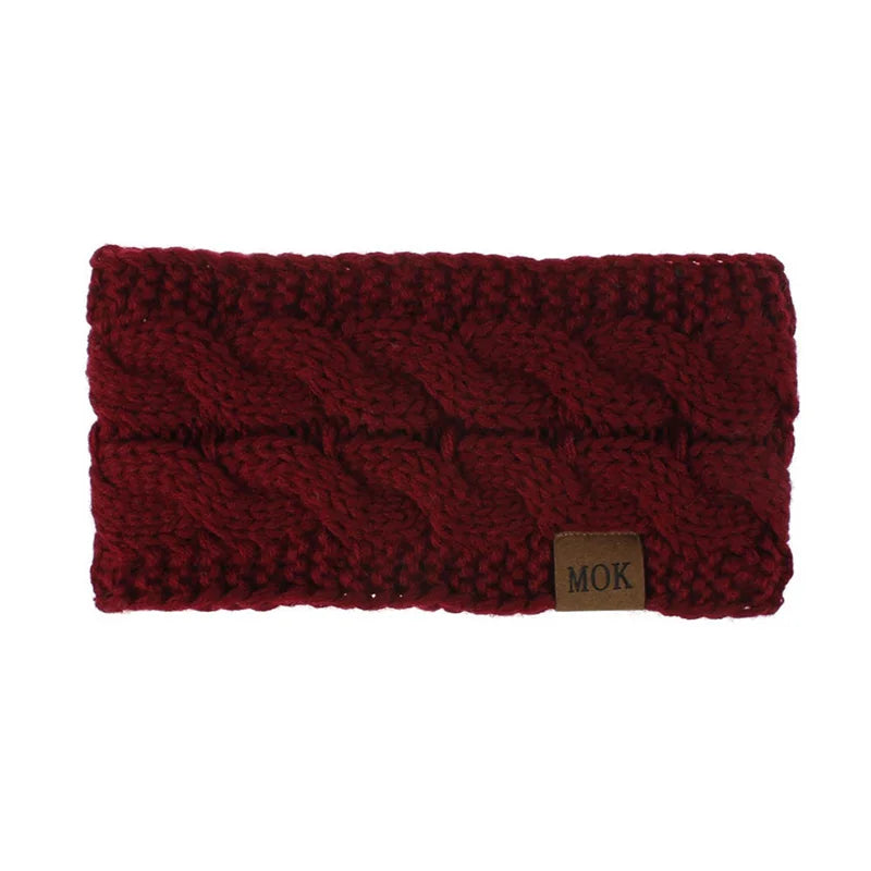 A maroon knitted plush winter ear warmer headband with a small brown tag.