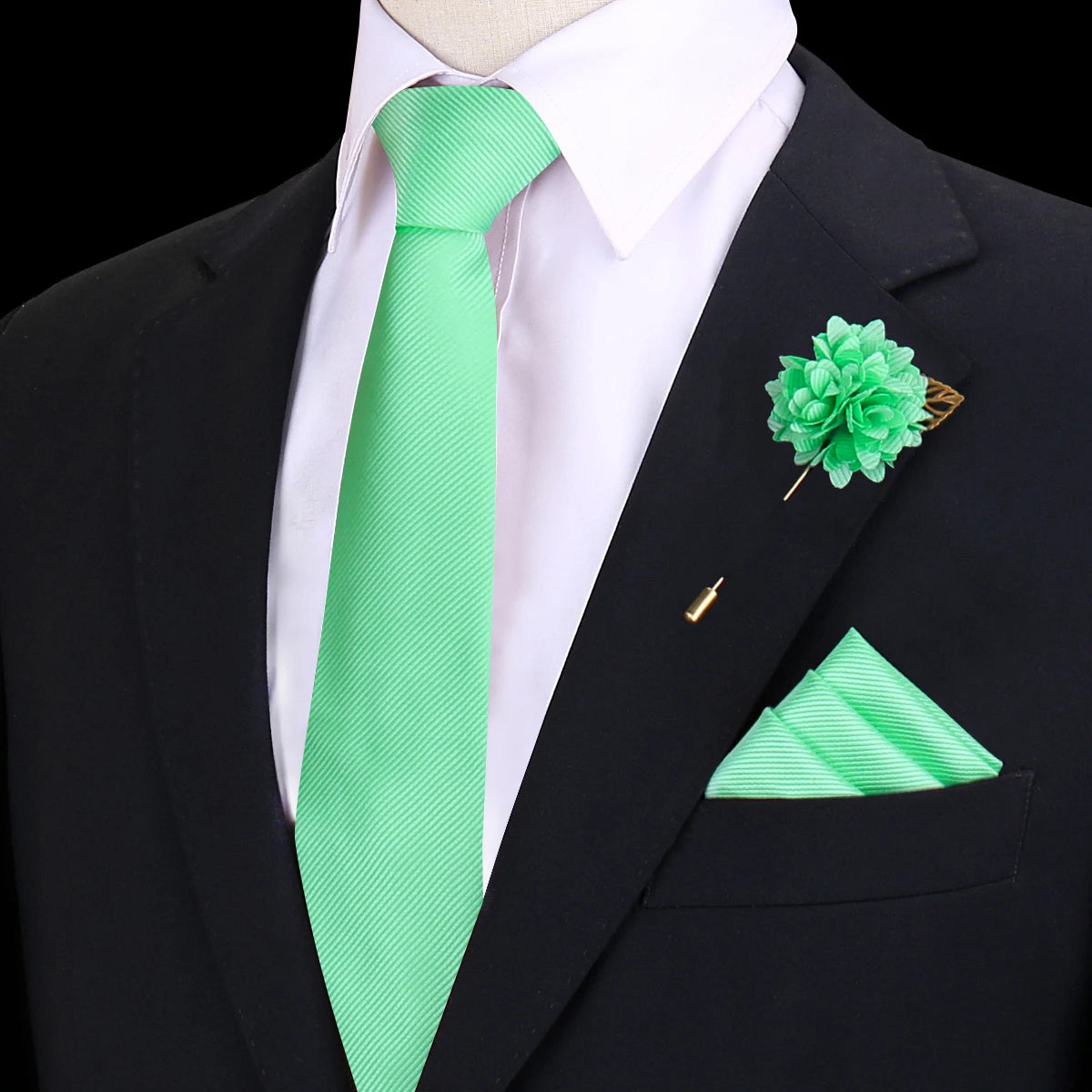 Chaqueta negra con camisa blanca y corbata de seda verde lima brillante, prendido con una flor verde floral