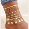 Gold stainless steel snake chain anklets layered on a woman's foot.