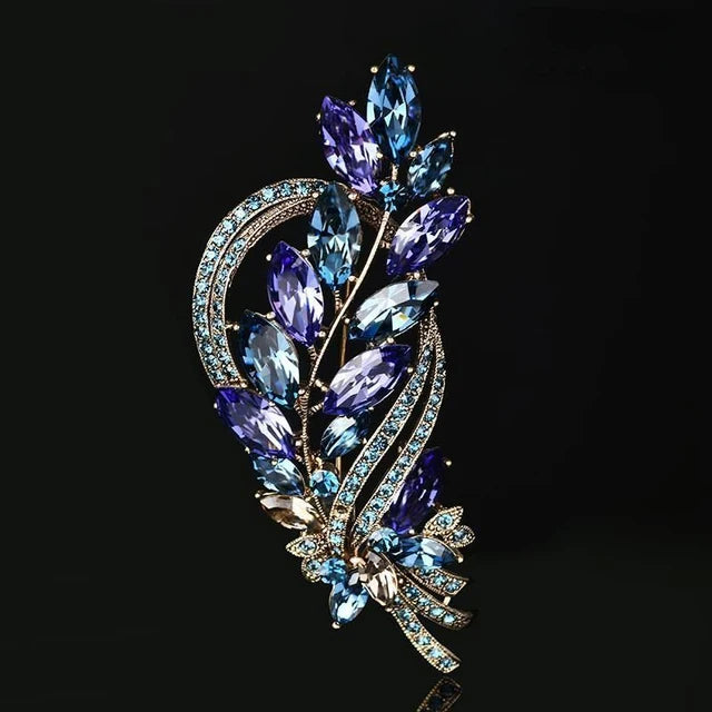 Broche florale en cristal élégante avec des pierres bleues et violettes.