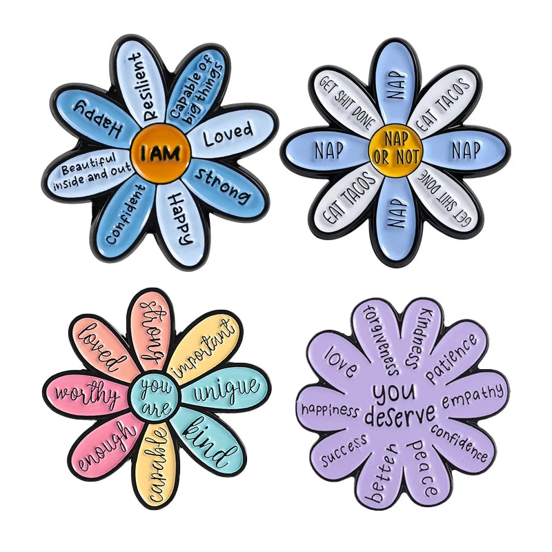 A set of enamel flower brooches featuring inspirational words like Happy Loved Strong and ingredients for success and kindnes