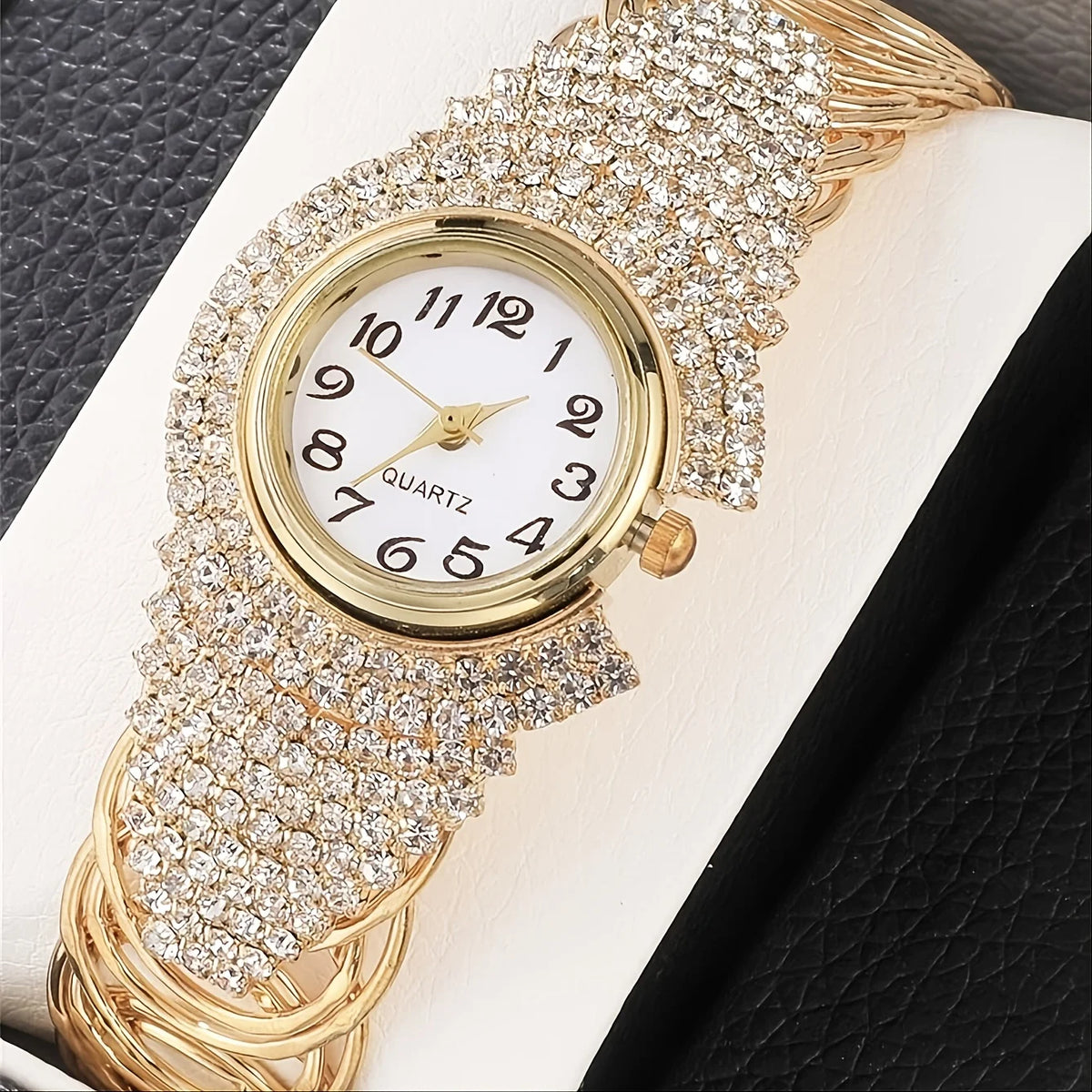 A gold-toned quartz wristwatch adorned with full pave rhinestones on the bezel and bracelet.