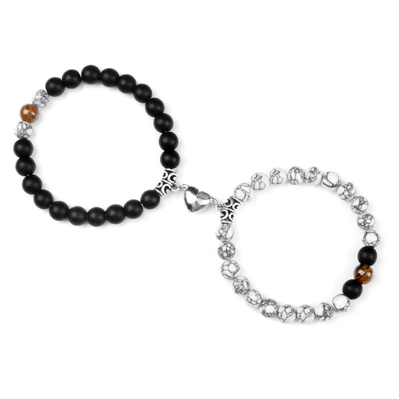 A pair of natural stone heart couple bracelets featuring black and silver beads.