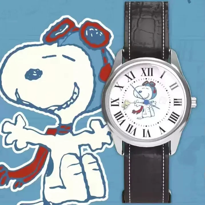 Eine silberne Uhr mit schwarzem Armband neben einer weißen Cartoon-Zeichnung von Snoopy