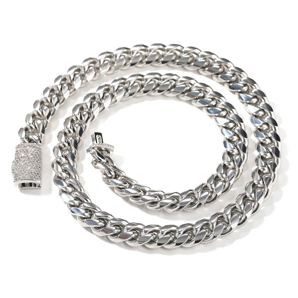 A silver stainless steel Cuban link necklace coiled on a white background.