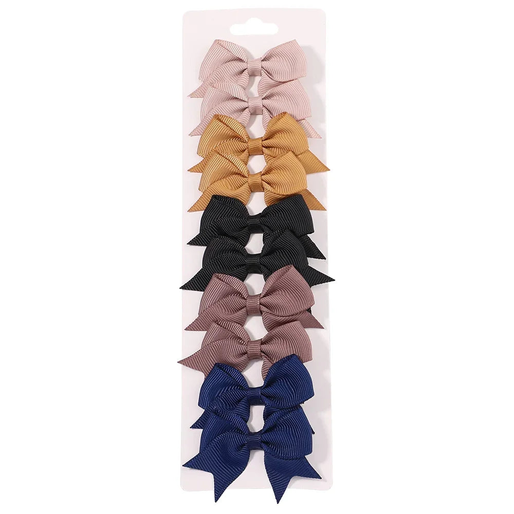 A collection of handmade ribbon bow hair clips in various pastel and neutral colors.