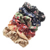 Una pila de seis gomas para el pelo de satén con estampado floral en varios colores, incluyendo negro, azul marino, verde oli