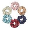 Un set de seis gomas de tela satinada con diferentes estampados y colores florales para el cabello