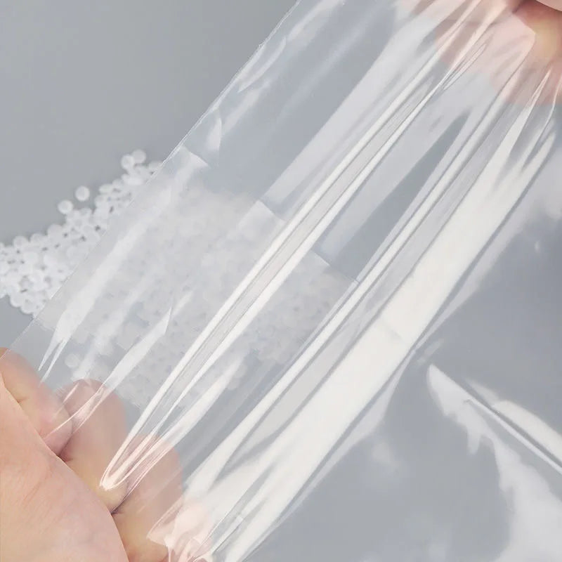 A hand is holding a clear reusable ziplock storage bag filled with white material.