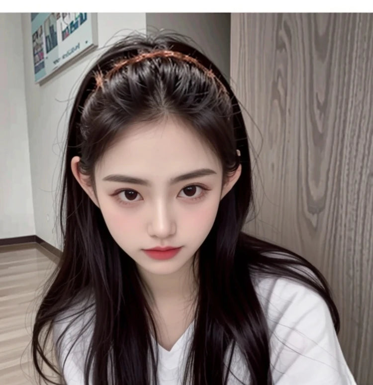 A close-up photo of a woman wearing a brown resin wave toothed headband on her dark hair.