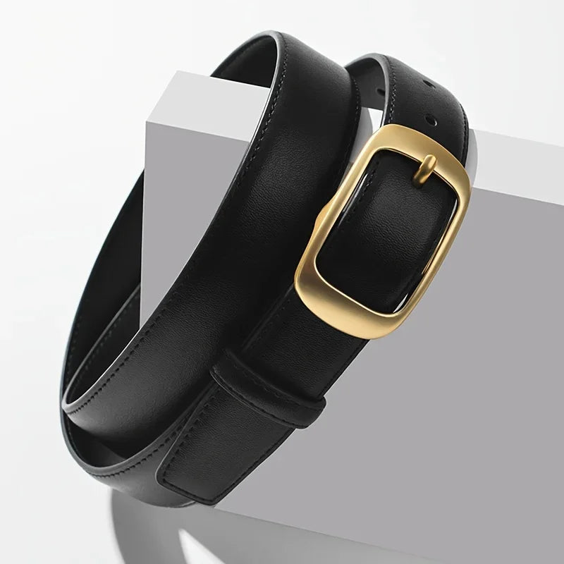 A black leather belt with a gold-toned buckle is displayed on a white surface.