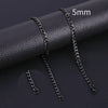 A close-up photo of a black stainless steel Cuban link necklace with a 5mm chain, displayed on a dark leather surface.