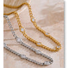 Three gold and silver charm necklaces with clear cubic zirconia stones displayed on a light surface.