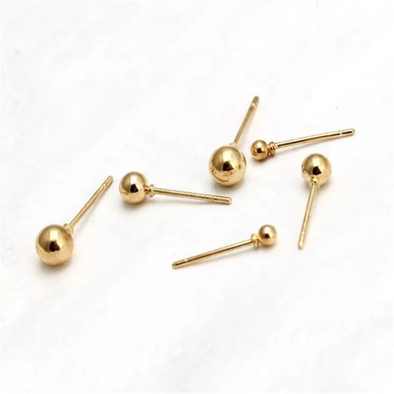 A set of three gold-toned round stud earrings on thin gold-toned posts.