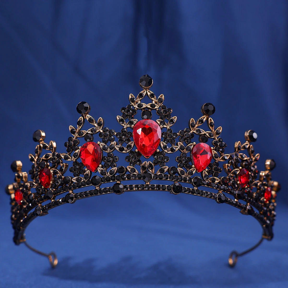 A dark gold crown set featuring red crystal rhinestones and black accents.