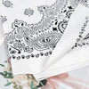 White cotton paisley bandana scarf folded and displayed with floral accents