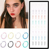 A set of stainless steel nose studs and rings for body piercing displayed against a dark background.