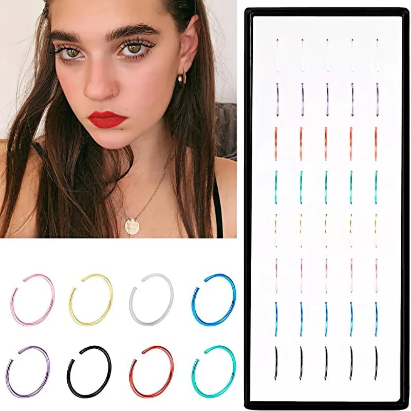 A set of stainless steel nose studs and rings for body piercing displayed against a dark background.