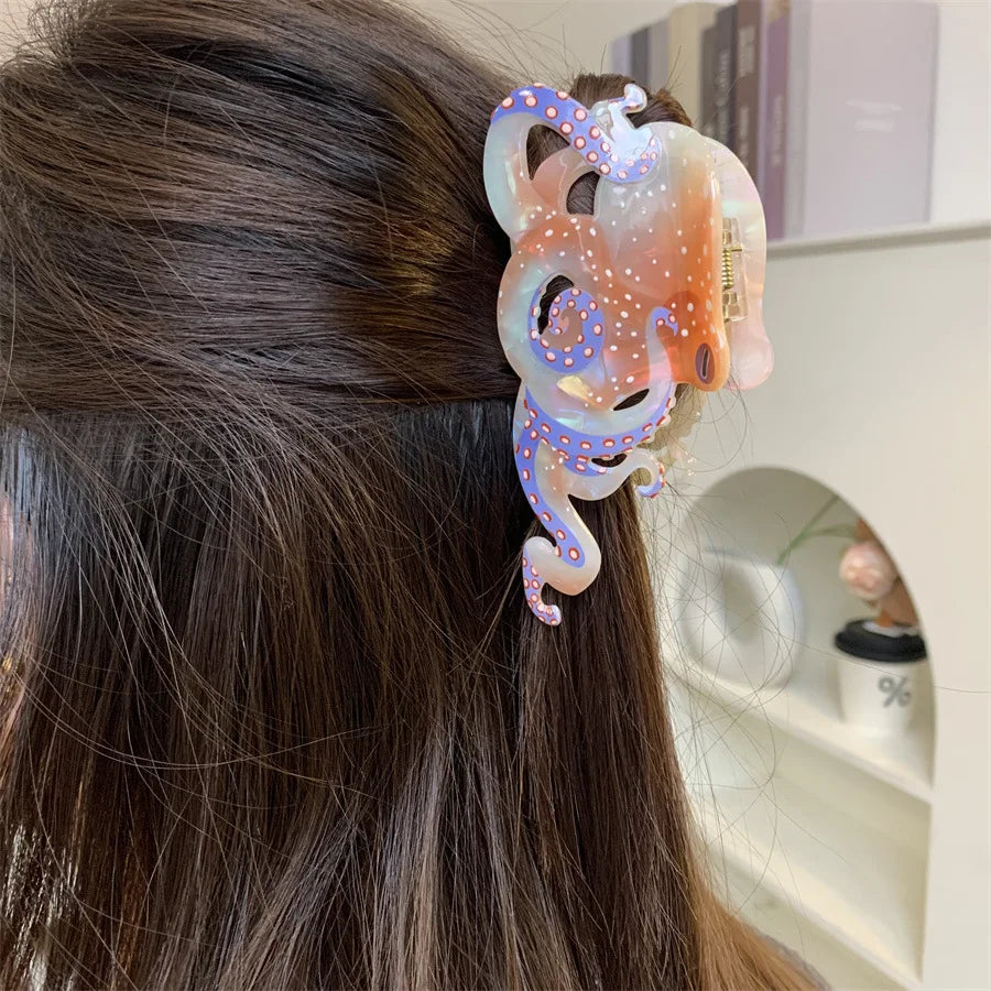 Quelques pinces à cheveux en forme d'œufs d'anis colorées d'octopode avec des tons roses et bleus irisants