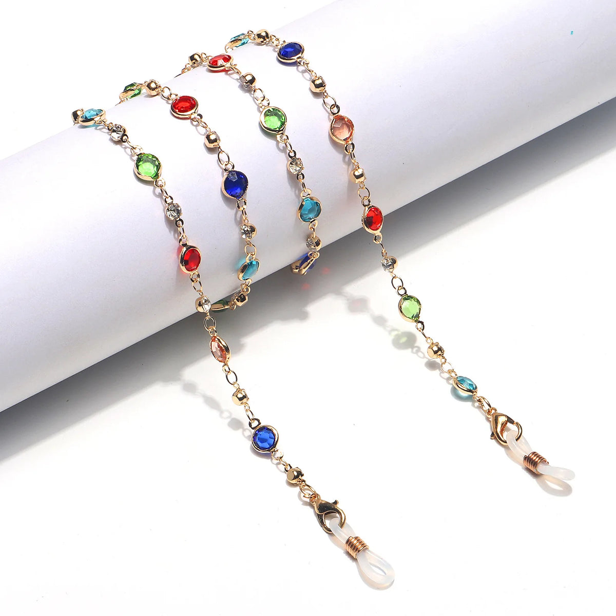 Una delicada cadena de oro con cuentas de cristal de colores, usada como cadena para gafas de mujeres.