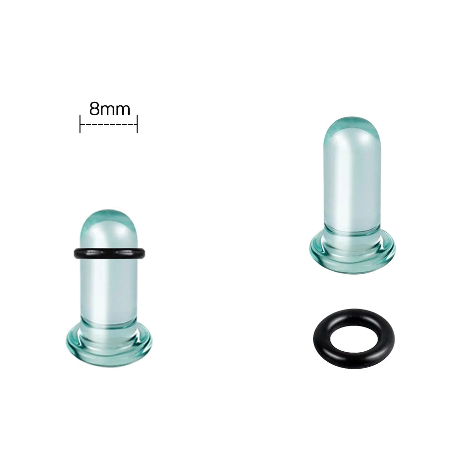 A glass ear stretching kit showing a cylindrical plug and a black ring.