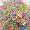 A pile of colorful disposable hair scrunchies in various bright colors like pink, yellow, green, and blue.