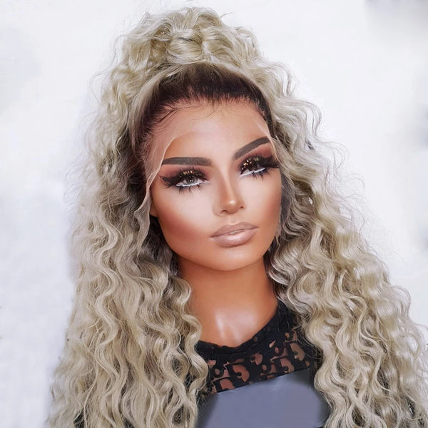 A close-up of a model wearing a long curly ombre lace front wig with light blonde and darker highlights.