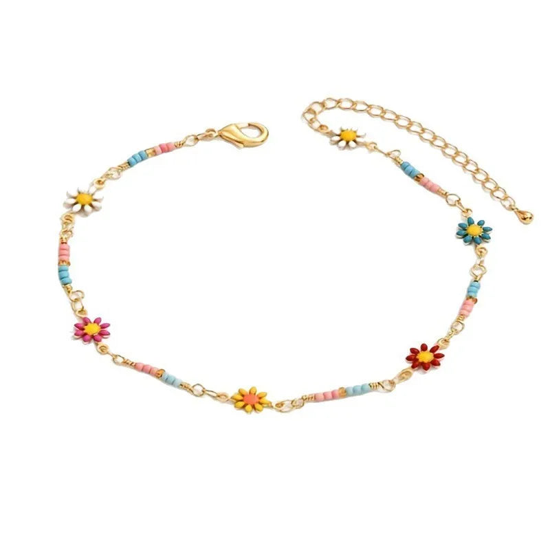 Goldene Nelkenkette als Fußketti für Damen mit kleinen Blumen- und bunten Perlen-Charms