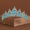 Diadema de tiara de cristal azul con piedras brillantes sobre una caja marrón.