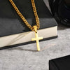 A gold stainless steel Cuban link necklace with a cross pendant resting on an open book.