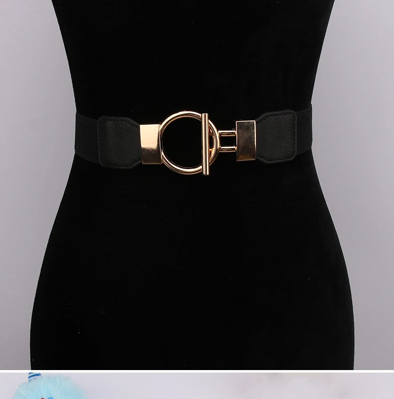 A black belt with a gold round buckle and black fabric strap displayed on a black mannequin.