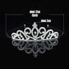 Tiara y corona de cristal brillante para el cabello, exhibida contra un fondo negro.