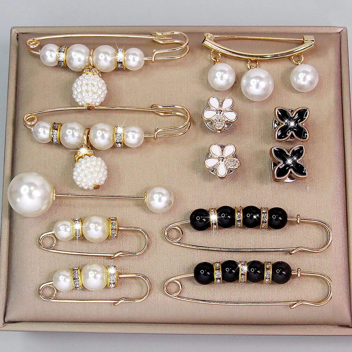 A set of gold-toned adjustable pearl jewelry including necklaces and earrings displayed in a box.