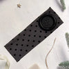 Black stretch hairband with a circular grip and small dots on a white background.