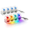 A collection of colorful clickable LED fidget keychains arranged in a row and scattered on a white surface.