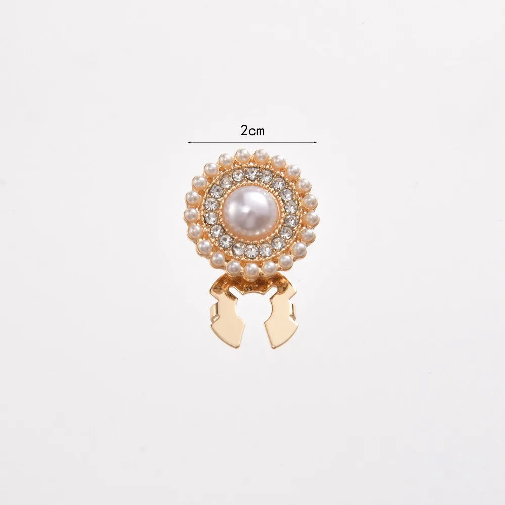 Gold floral button cufflinks featuring a pearl centerpiece and surrounding clear stones.