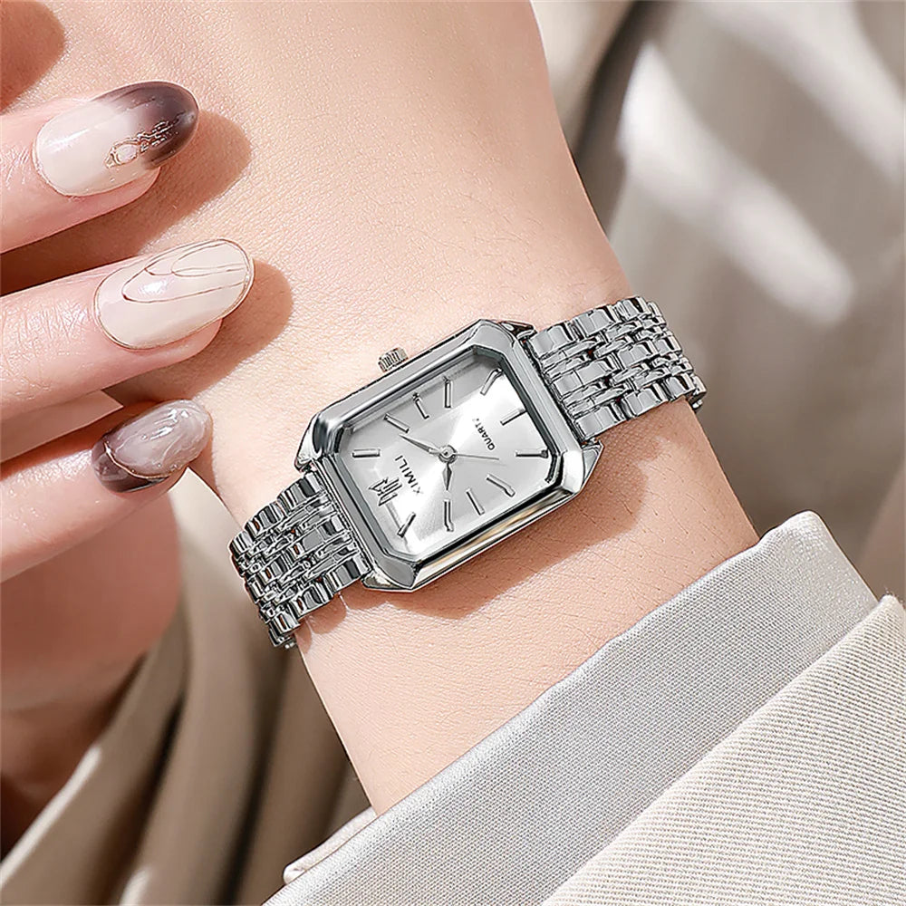 A close-up of an elegant gold-plated quartz fashion watch worn on a wrist, with manicured nails visible.