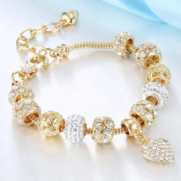 Goldenes und transparentes Strassarmbandset aus Perlen für Damen auf weißem Hintergrund.