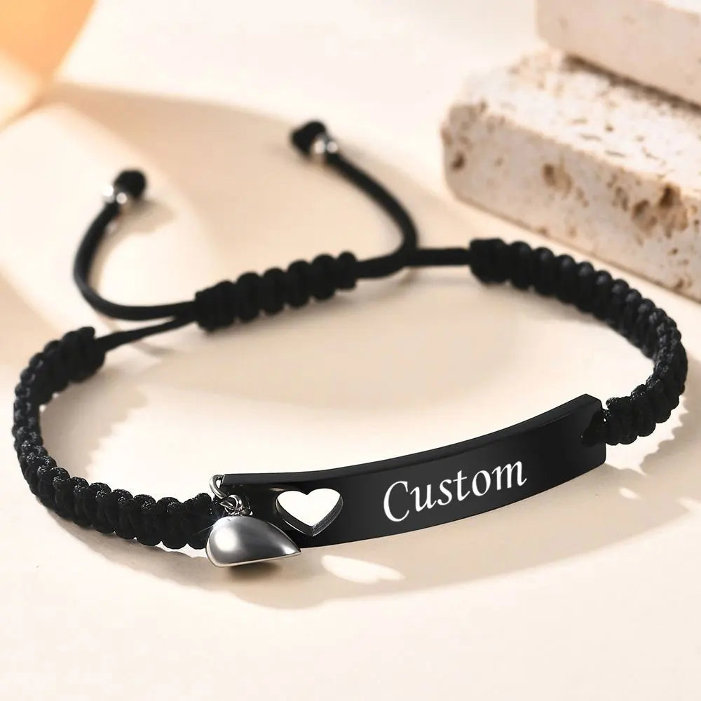 Schwarzes Perlenarmband mit silbernem Herzcharm und individueller Gravur auf Lederriemen.
