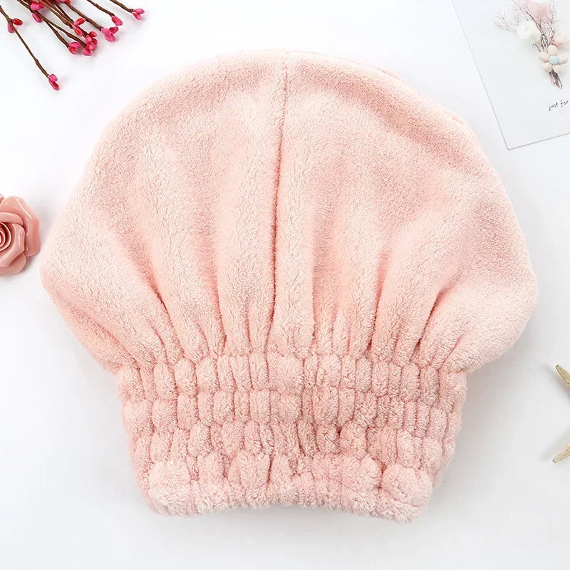 A soft pink microfiber hair drying towel with a fluffy texture is shown on a white background.