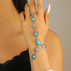 A hand is wearing a silver beaded bracelet set featuring turquoise and silver beads.